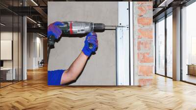 Сonstruction contractor drilling wall for garage door opener installation. Wall mural