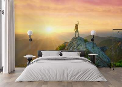 Silhouette of a champion on mountain top. Travel and adventure. Mountain hiking. Mountains during sunrise. Success and goal achievement. People success-image Wall mural