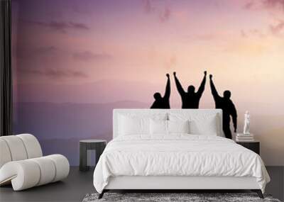 Silhouettes of team on mountain peak. Sport and active life concept. Wall mural