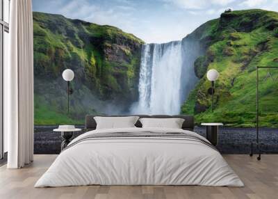 Skogafoss waterfall, Iceland. Mountain valley and clear sky. Natural landscape in summer season. Icelandic nature. Group of a people near large waterfall. Travel image Wall mural