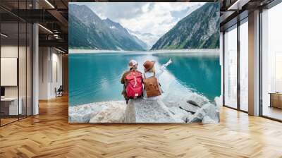 Travelers couple look at the mountain lake. Travel and active life concept with team. Adventure and travel in the mountains region in the Austria. Travel - image Wall mural