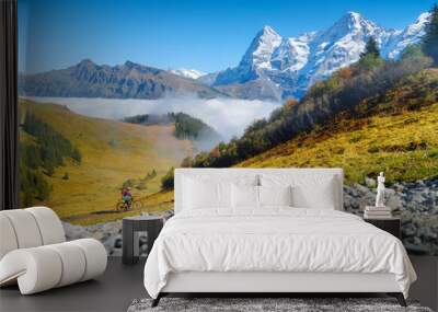 Two people riding bicycles in the mountains. A team sport. Cyclists in a mountain valley in the Alps. Traveling on a bicycle. High resolution picture for the background. Wall mural