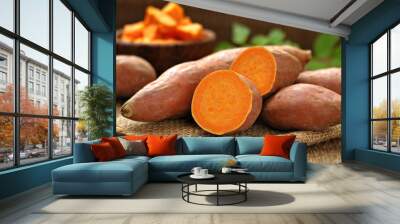 Raw sweet potatoes on burlap, blurred background. Wall mural