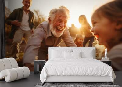 Happy senior grandfather in garden playing with grandchildren in retirement. 70 year old healthy man. Wall mural