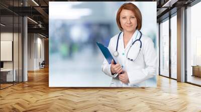 Attractive young female doctor with blurred hospital interior on Wall mural