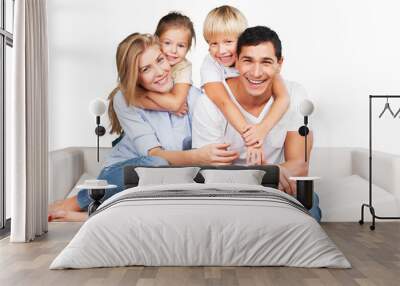 Beautiful smiling family sitting at sofa at home Wall mural