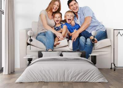 Beautiful smiling family sitting at sofa at home Wall mural