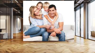 Beautiful smiling family sitting at sofa at home Wall mural