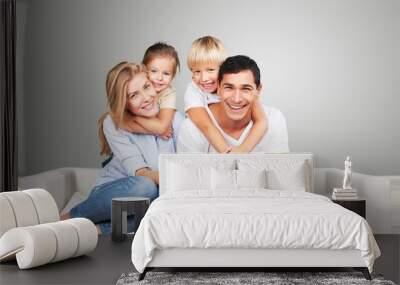 Beautiful smiling family sitting at sofa at Wall mural