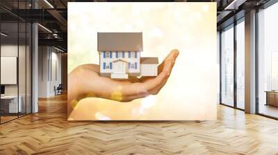 Building, mortgage, real estate and property concept - close up of hand holding house model Wall mural