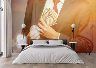 Businessman hiding dollars banknotes in the pocket of jacket Wall mural