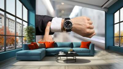 Businessman pointing at hand watch on grey Wall mural