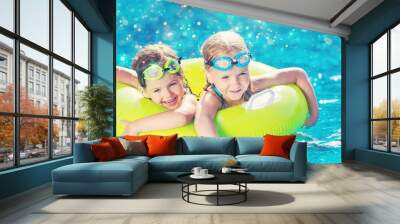 Children playing in pool. Two little girls having fun in the pool. Summer holidays and vacation concept Wall mural