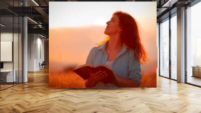 Christian woman holds bible book in her hands. Wall mural