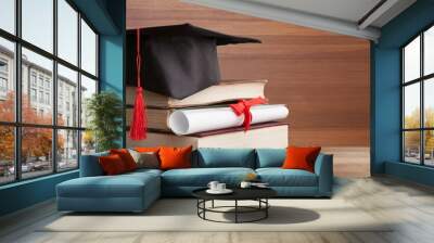 Graduation hat on a stack of books and diploma Wall mural