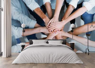 Group of people stacking hands together Wall mural