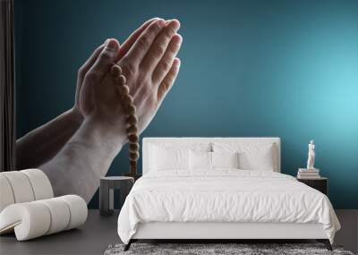 Hands clasped. Man hands in praying position on dark background. Faith in religion Wall mural