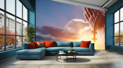 Hands with wooden cross on sky background Wall mural