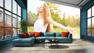 Happy woman with arms open on natural background Wall mural