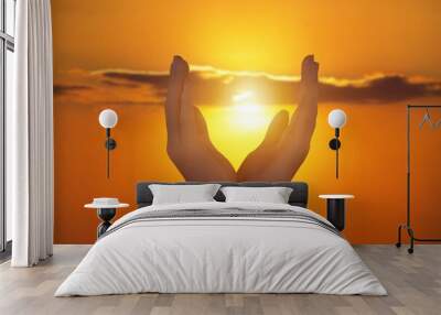 Human hands on golden sky background Wall mural