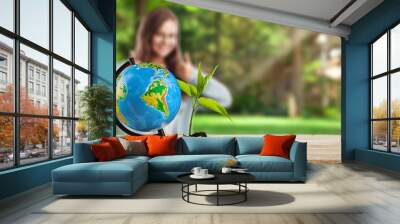 Little girl with green plant and Earth globe Wall mural