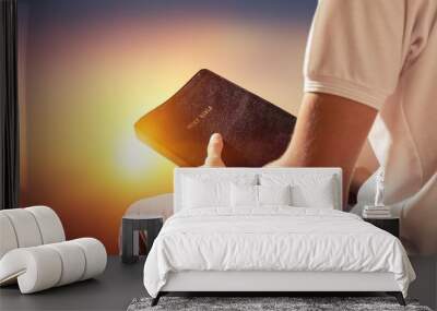 Man reading old Bible book on background Wall mural