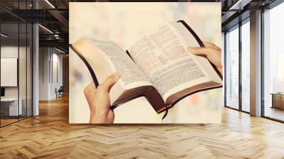 Man reading old Bible book on background Wall mural