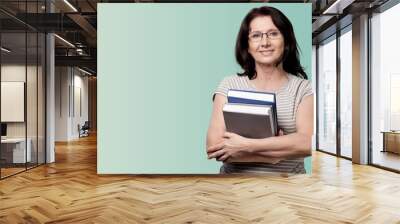 Mature woman teacher with books on background Wall mural