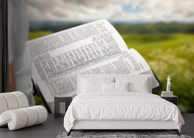 Person reading book praying with Bible Wall mural