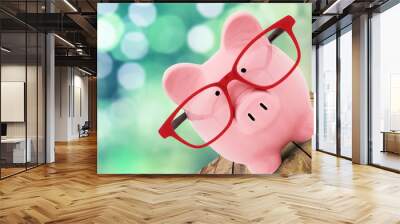 Piggy bank in glasses on background Wall mural