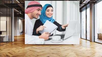 Portrait of arab couple with laptop on  background Wall mural