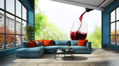 Red wine pouring in glass Wall mural