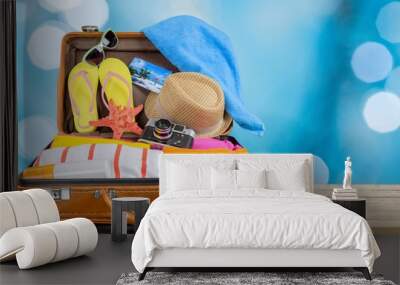 Retro suitcase with travel objects on wooden Wall mural