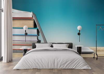 Stack of books with a modern laptop on the table Wall mural