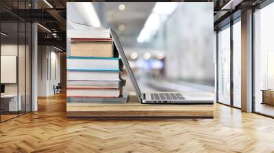 Stack of books with laptop on wooden table Wall mural