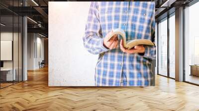 The Bible book is in hands of praying person Wall mural