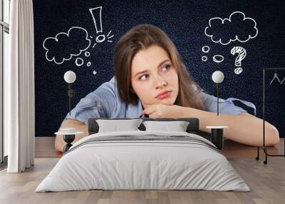 Thoughtful female young Student sitting at desk Wall mural