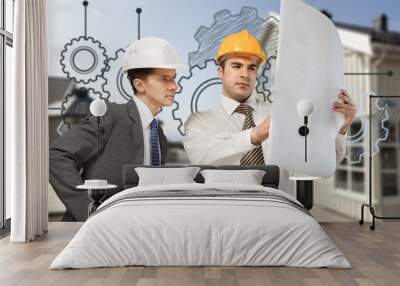 Two engineers men at construction site watching blueprint Wall mural