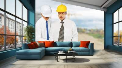 Two engineers men at construction site watching Wall mural