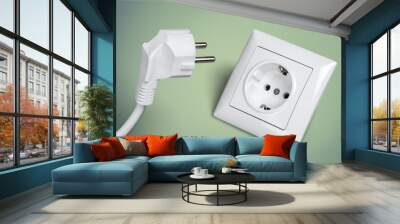 White electrical plug in the electric socket on a wall Wall mural