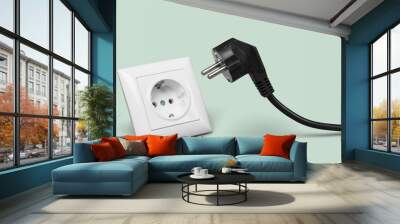 White electrical plug in the electric socket on a wall Wall mural