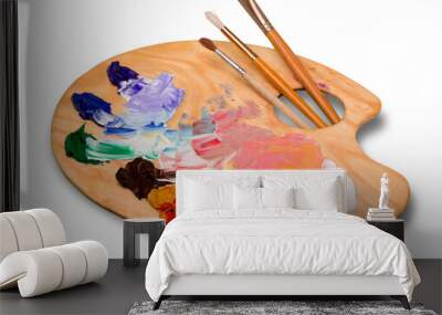 Wooden art palette with blobs of paint and a brushes on white background Wall mural