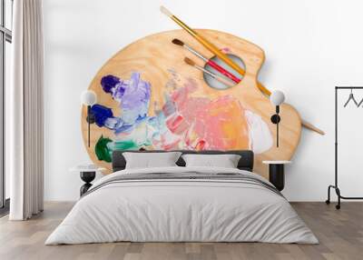 Wooden art palette with blobs of paint and a brushes on white background Wall mural