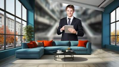 Young businessman posing outdoor at office building. Wall mural