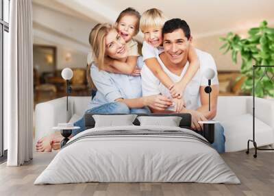 Young  family at home smiling at camera Wall mural