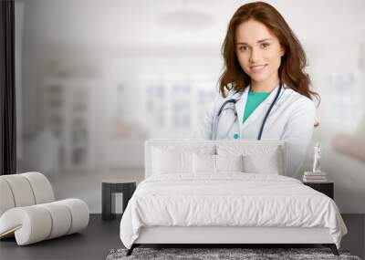 Young female doctor with stethoscope on blurred hospital Wall mural