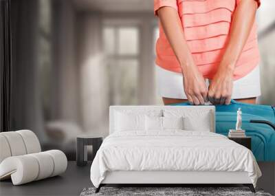 Young woman in hotel room holding suitcase Wall mural