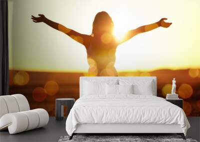 Young woman on field under sunset light Wall mural