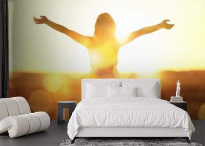 Young woman on field under sunset light Wall mural