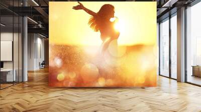 Young woman on field under sunset light Wall mural